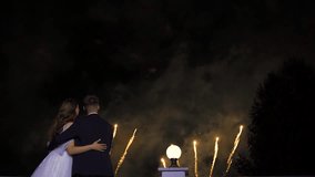 Wedding fireworks celebration. Unfamiliar couple shares tender moment under shimmering fireworks. Romantic scene of newlyweds enjoying sparkling fireworks from their balcony during celebration - Powered by Shutterstock - Get 15% off with code: PIKWIZARD15
