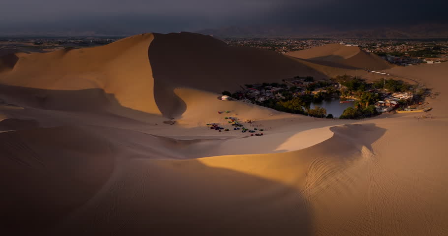 Buggies and sand dunes with oasis in Huacahina, Peru. Tourism, travel destination. Aerial