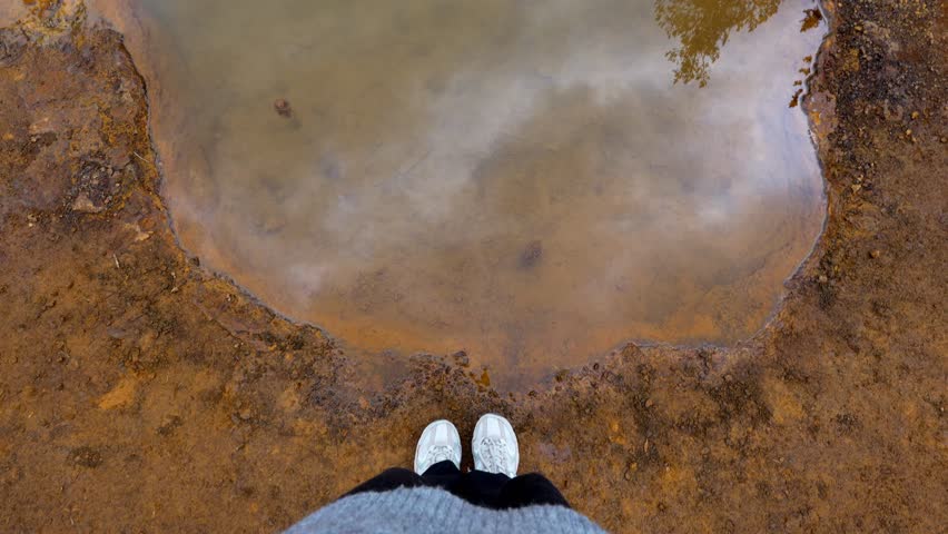 Woman standing on the colorful ochre banks of Paint Pots mineral springs in Kootenay National Park