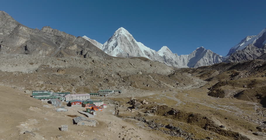 Aerial shot of Himalayan settlement with small shops and trekking lodges in Lobuche along Everest Base Camp route with Pumori and Nuptse peaks in Everest region Nepal.