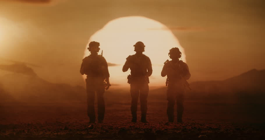 Silhouettes of Three Armed Army Soldiers Walk Across a Desert War Zone at Sunset With a Helicopters in Background. Peace Mission Patrol, Combat Action, Special Forces Military. Cinematic Slow Motion