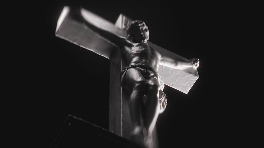 Sculpture of Jesus Christ Crucified on Cross on Black Background. Symbol of Faith, Redemption, and Good Friday Tradition For Easter Season. Religious Concept of Passion of Christ and Divine Sacrifice.