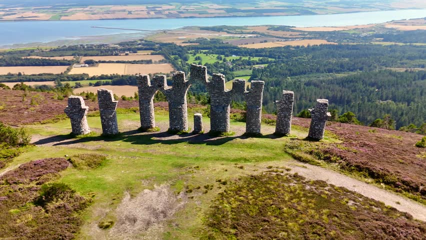 Cinematic Drone Aerial View of Fyrish Monument with Purple Heather in Bloom, Historic Stone Arches on Fyrish Hill Overlooking Cromarty Firth, Scottish Highlands Landscape, Evanton, Scotland, UK.