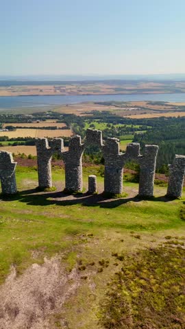 Cinematic Drone Aerial View of Fyrish Monument with Purple Heather in Bloom, Historic Stone Arches on Fyrish Hill Overlooking Cromarty Firth, Scottish Highlands Landscape, Evanton, Scotland, UK.