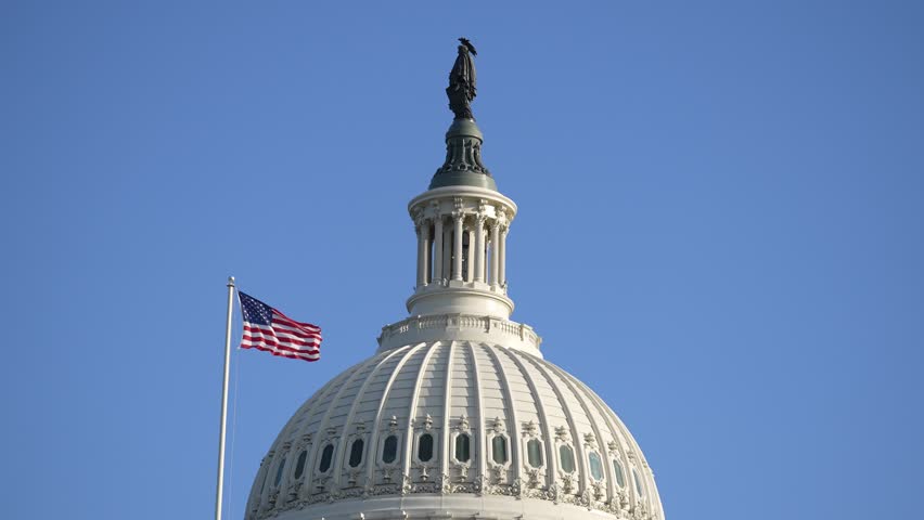 Capitol with American flag waving. Congress and legislative power. Congress in Washington DC skyline. Congress and Senate chambers. Congress under the Capitol roof.