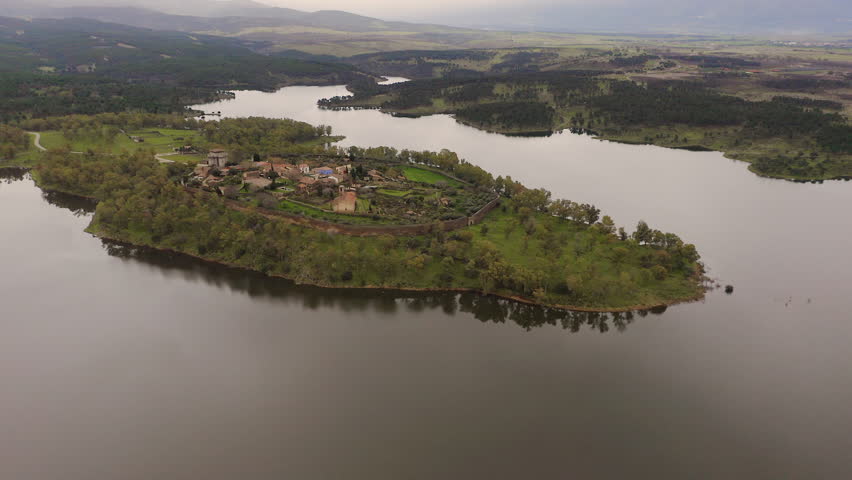 Aerial view of the ruins of Granadilla, a fortified medieval village in Cáceres, Spain, surrounded by Gabriel y Galán Reservoir. Historic walled town with castle tower and rural landscape in western Iberian Peninsula.