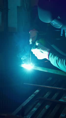 Welder performs arc welding of metal structures. Concept of welding of metal structures.