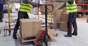 Workers loading boxes with pallet truck in warehouse. Two workers in safety vests move parcels and packages for delivery, shipping and storage. Concept of efficient warehouse logistics teamwork. - Powered by Shutterstock - Get 15% off with code: PIKWIZARD15