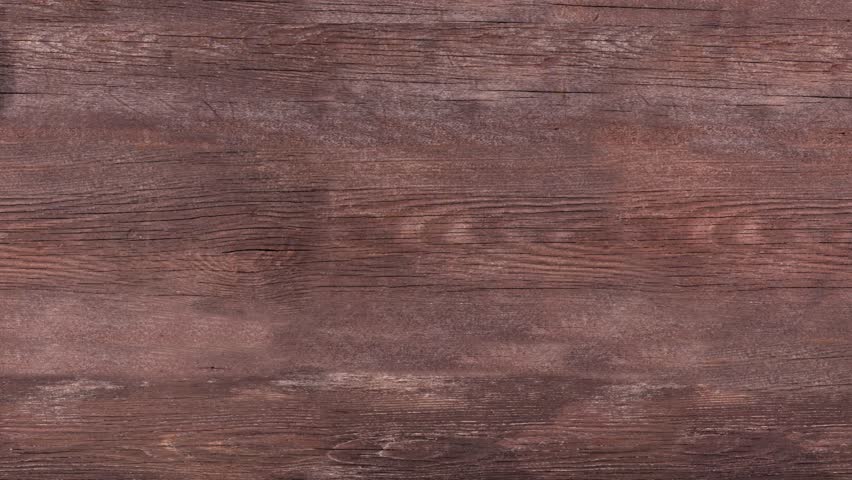 Table scene of take out or delivery foods. Stop motion table placement video. Pizza, hamburgers, fried chicken and sides. Above view on a dark wood background.