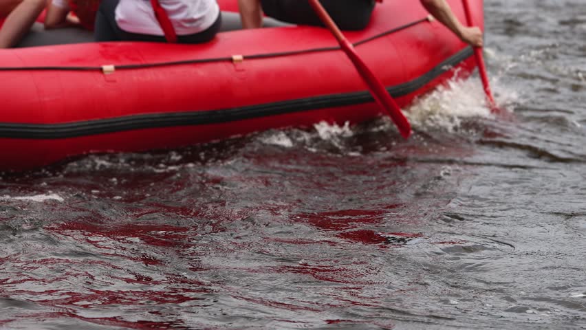 Rafting in whitewater, extreme water sports on water rapids, kayaking and canoeing tour in a mountain river,  water sports team, red and yellow raft boat full of tourists in a summer day, slow motion