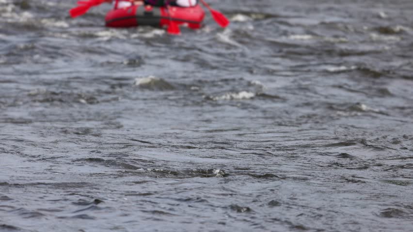 Rafting in whitewater, extreme water sports on water rapids, kayaking and canoeing tour in a mountain river,  water sports team, red and yellow raft boat full of tourists in a summer day, slow motion