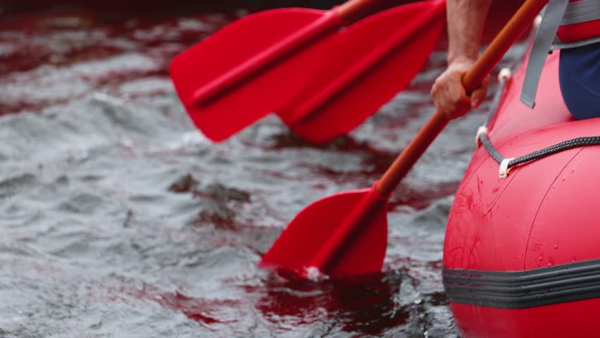 Rafting in whitewater, extreme water sports on water rapids, kayaking and canoeing tour in a mountain river,  water sports team, red and yellow raft boat full of tourists in a summer day, slow motion