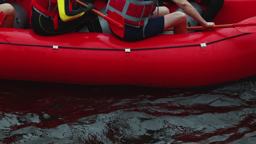 Rafting in whitewater, extreme water sports on water rapids, kayaking and canoeing tour in a mountain river,  water sports team, red and yellow raft boat full of tourists in a summer day, slow motion