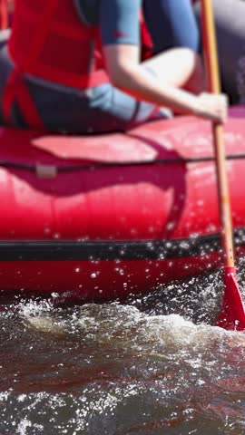 Rafting in whitewater, extreme water sports on water rapids, kayaking and canoeing tour in a mountain river,  water sports team, red and yellow raft boat full of tourists in a summer day, slow motion