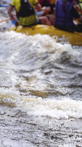 Rafting in whitewater, extreme water sports on water rapids, kayaking and canoeing tour in a mountain river,  water sports team, red and yellow raft boat full of tourists in a summer day, slow motion