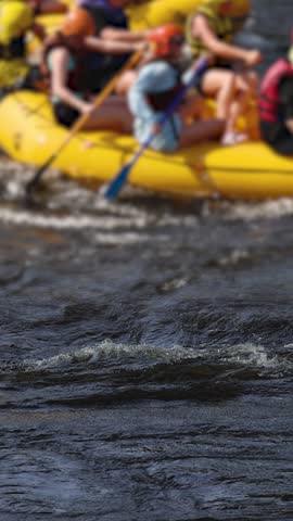 Rafting in whitewater, extreme water sports on water rapids, kayaking and canoeing tour in a mountain river,  water sports team, red and yellow raft boat full of tourists in a summer day, slow motion