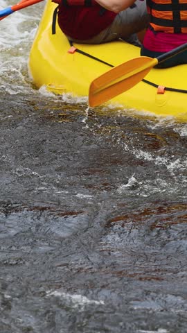 Rafting in whitewater, extreme water sports on water rapids, kayaking and canoeing tour in a mountain river,  water sports team, red and yellow raft boat full of tourists in a summer day, slow motion