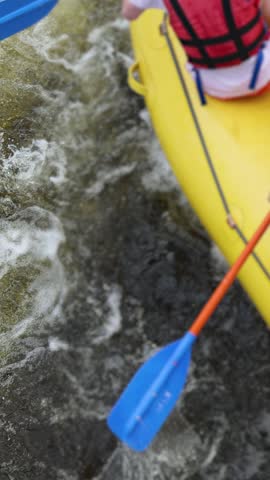 Rafting in whitewater, extreme water sports on water rapids, kayaking and canoeing tour in a mountain river,  water sports team, red and yellow raft boat full of tourists in a summer day, slow motion