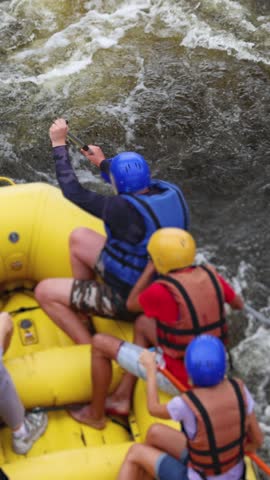 Rafting in whitewater, extreme water sports on water rapids, kayaking and canoeing tour in a mountain river,  water sports team, red and yellow raft boat full of tourists in a summer day, slow motion