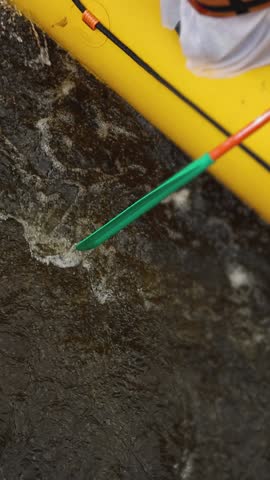 Rafting in whitewater, extreme water sports on water rapids, kayaking and canoeing tour in a mountain river,  water sports team, red and yellow raft boat full of tourists in a summer day, slow motion