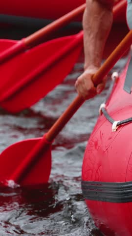 Rafting in whitewater, extreme water sports on water rapids, kayaking and canoeing tour in a mountain river,  water sports team, red and yellow raft boat full of tourists in a summer day, slow motion