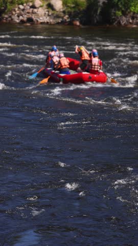Rafting in whitewater, extreme water sports on water rapids, kayaking and canoeing tour in a mountain river,  water sports team, red and yellow raft boat full of tourists in a summer day, slow motion