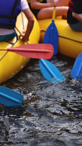 Rafting in whitewater, extreme water sports on water rapids, kayaking and canoeing tour in a mountain river,  water sports team, red and yellow raft boat full of tourists in a summer day, slow motion