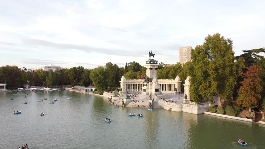Aerial view of tourists on boats enjoying an autumn day on a great pond in front of monument to Alfonso XII at the Retiro Park (Parque del Buen Retiro) in Madrid, Spain.