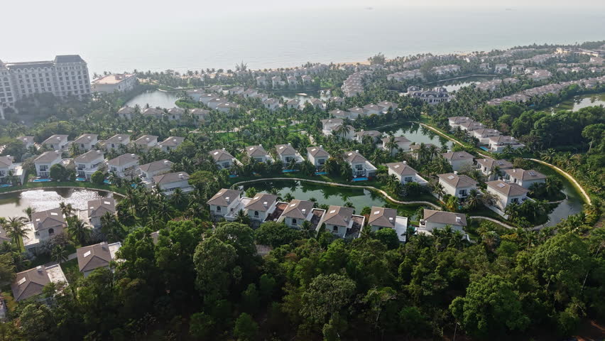 Phu Quoc Island, Vietnam, Drone Shot of Luxury Villas With Swimming Pools Around Lake by Beach in Grand World Complex