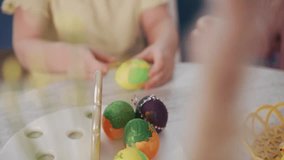 Child carefully paints eggs with bright colors. Hands focused, showing patience and joy. Table holds more decorated eggs nearby. Perfect for Easter, family crafts, or childhood creativity themes - Powered by Shutterstock - Get 15% off with code: PIKWIZARD15