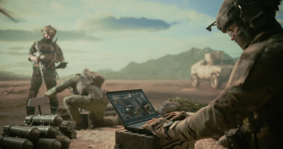Special Operations Soldiers at Digital Base in a Middle East Desert War, Using Laptop to Monitor Targets, Precision Strike Planning Beside Munitions, Helicopter Overwatch, Armored Transport