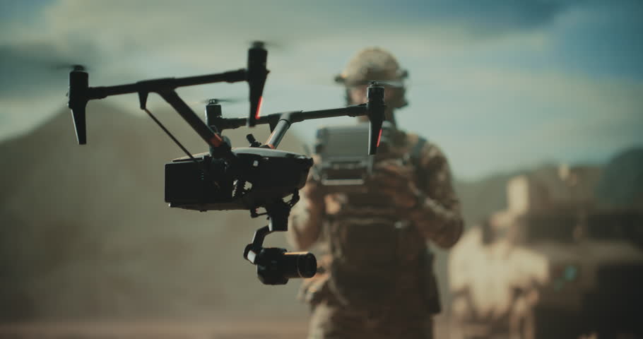 Special Forces Drone Operator Hovers a Tactical Quadcopter Drone at a Desert Base, Battlefield Mapping, Precision Strike, Target Tracking,Reconnaissance With a Control Station Modern Warfare War
