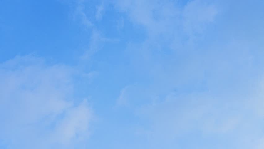Hand holds single light bulb against bright blue sky