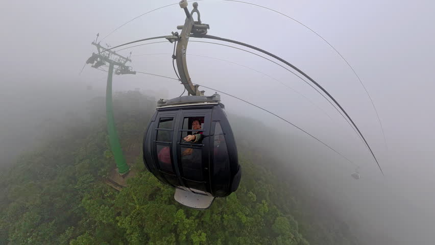 Cable Car Approaching Support Tower in Thick Mist While Ascending Bana Hills Seen from Wide Angle Aerial Angle.