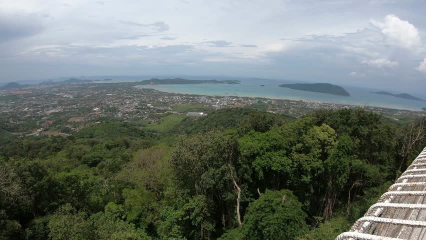 A breathtaking view from a hilltop, showcasing the vibrant coastal landscape and tranquil ocean, surrounded by lush greenery and distant islands. Perfect for nature lovers and travel enthusiasts seeki