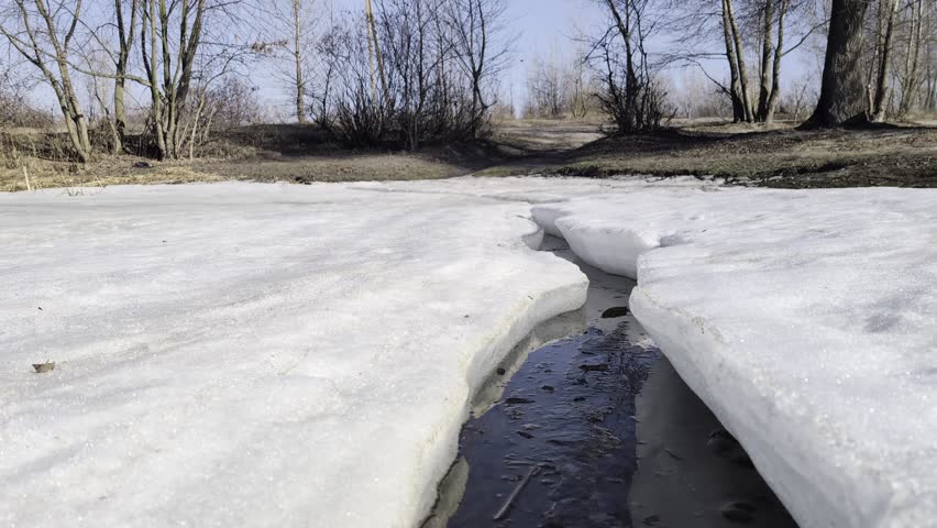 Early spring riverside landscape with melting thick river ice