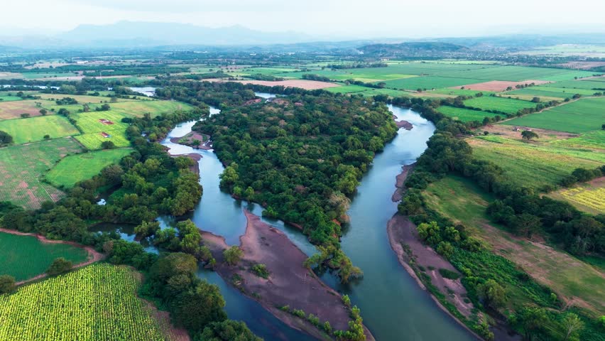 Aerial view of the santiago river winding through lush green agricultural fields in nayarit, mexico