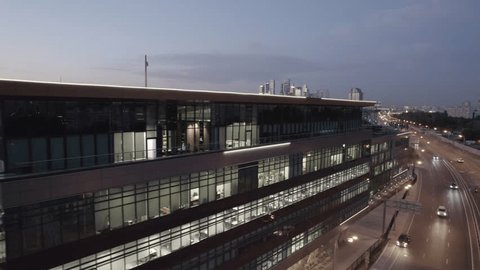 Drone Moving Forward along Glowing Office Building