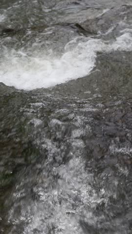 Powerful Rushing River Water Close Up 

Cinematic close up of white water rapids flowing over rocks in a mountain stream. Natural splashing river current.