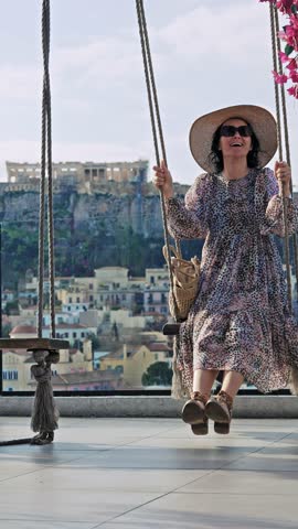 Woman joyfully swinging with the Athens Acropolis in the background