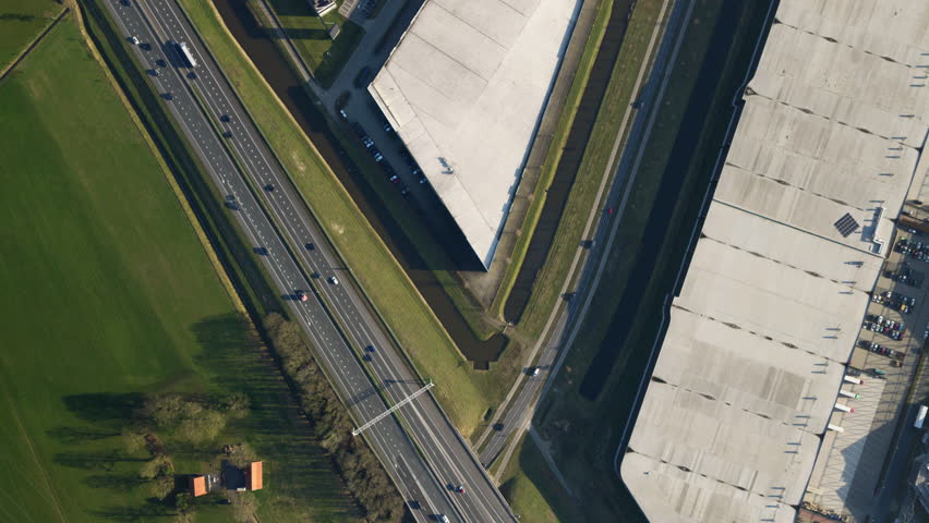 Aerial view of highway interchange beside modern warehouses in Netherlands top shot.