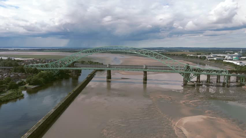 Liverpool, Merseyside, UK, September 09, 2025; aerial 4K video footage of the Silver Jubilee Bridge and Britannia Railway Viaduct over the River Mersey and Manchester Ship Canal, Runcorn, Merseyside