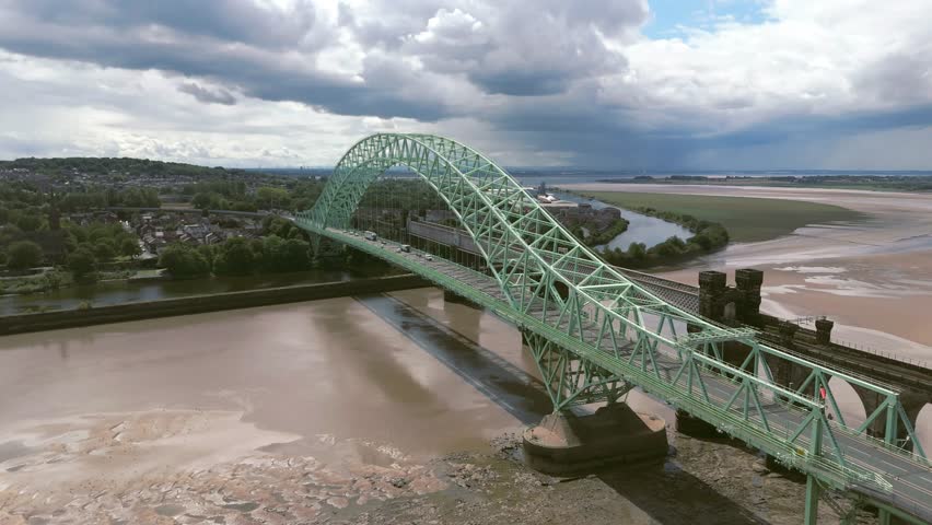 Liverpool, Merseyside, UK, September 09, 2025; aerial 4K video footage of the Silver Jubilee Bridge and Britannia Railway Viaduct over the River Mersey and Manchester Ship Canal, Runcorn, Merseyside