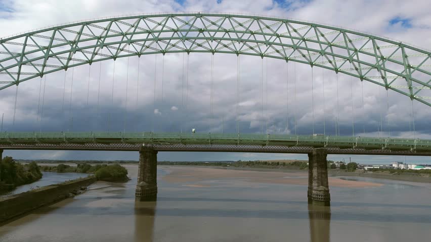 Liverpool, Merseyside, UK, September 09, 2025; aerial 4K video footage of the Silver Jubilee Bridge and Britannia Railway Viaduct over the River Mersey and Manchester Ship Canal, Runcorn, Merseyside