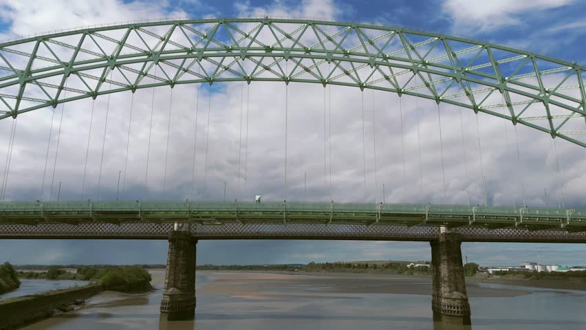 Liverpool, Merseyside, UK, September 09, 2025; aerial 4K video footage of the Silver Jubilee Bridge and Britannia Railway Viaduct over the River Mersey and Manchester Ship Canal, Runcorn, Merseyside
