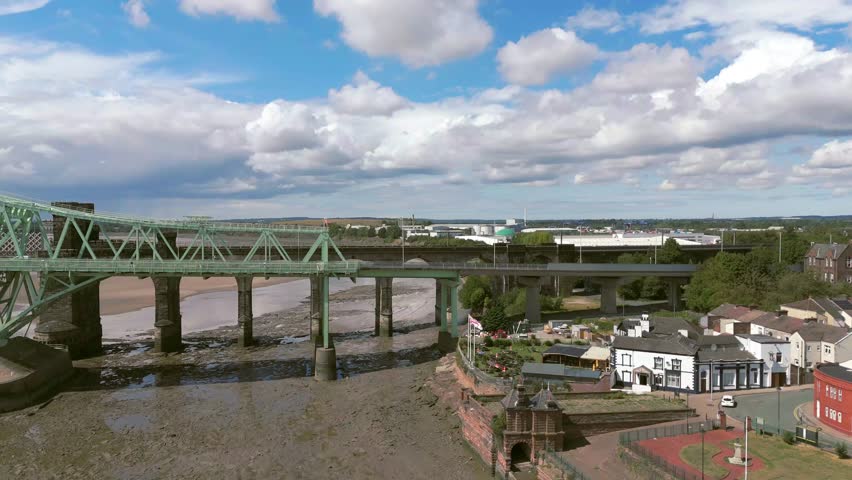 Liverpool, Merseyside, UK, September 09, 2025; aerial 4K video footage of the Silver Jubilee Bridge and Britannia Railway Viaduct over the River Mersey and Manchester Ship Canal, Runcorn, Merseyside