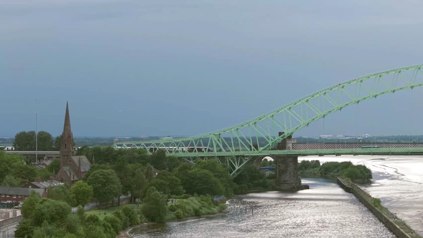 Liverpool, Merseyside, UK, September 09, 2025; aerial 4K video footage of the Silver Jubilee Bridge and Britannia Railway Viaduct over the River Mersey and Manchester Ship Canal, Runcorn, Merseyside
