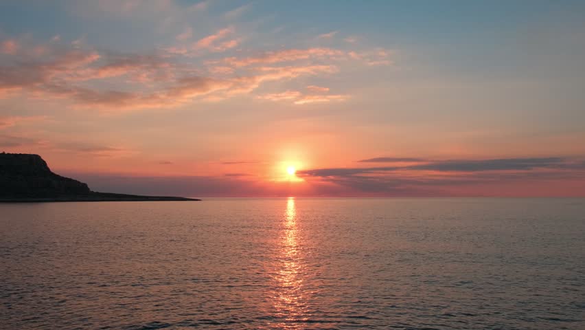 Red Sun Setting Over Calm Sea Horizon at Sunset. Golden Evening Sky and Red Sun Above Tranquil Sea. Romantic Tropical Sunset with Sun Descending into Ocean. Scenic Seascape with Bright Red Sun at Dusk