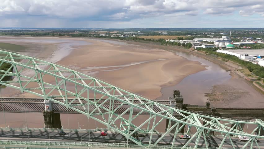 Liverpool, Merseyside, UK, September 09, 2025; aerial 4K video footage of the Silver Jubilee Bridge and Britannia Railway Viaduct over the River Mersey and Manchester Ship Canal, Runcorn, Merseyside