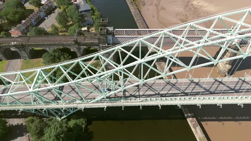 Liverpool, Merseyside, UK, September 09, 2025; aerial 4K video footage of the Silver Jubilee Bridge and Britannia Railway Viaduct over the River Mersey and Manchester Ship Canal, Runcorn, Merseyside